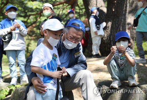 어린이와 대화하는 문재인 대통령(서울=연합뉴스) 안정원 기자 = 문재인 대통령이 어린이날인 5일 오후 청와대  녹지원에서  열린  '어린이날 100주년 기념 청와대 어린이 초청행사'에서 어린이와 휴식 시간 대화하고 있다.      이날 행사에는 벽지 분교및 개교 100주년을 맞은 초등학교 학생들이 초청됐다.   2022.5.5 jeong@yna.co.kr
