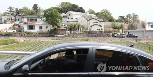 사저 구경(양산=연합뉴스) 김동민 기자 = 문재인 대통령 내외 귀향을 이틀 앞둔 8일 문 대통령 사저가 위치한 경남 양산시 하북면 평산마을에서 차량에 탑승한 시민이 사저를 바라보고 있다. 2022.5.8 image@yna.co.kr