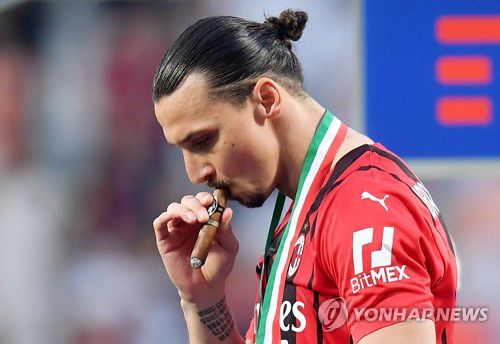 '시가'로 우승 자축하는 AC밀란 이브라히모비치(레조 에밀리아 로이터=연합뉴스) AC밀란의 즐라탄 이브라히모비치(40·스웨덴)가 22일(현지시간) 이탈리아 에밀리아로마냐주 사수올로의 마페이 스타디움에서 열린 이탈리아 세리에A 사수올로 대 AC밀란 경기에서 승리한 후 우승 세레머니에서 시가를 꺼내 들며 우승을 자축하고 있다. AC밀란은 이브라히모비치가 활약했던 2011년 세리에A에서 우승한 후 침체기를 겪으며 11년 동안 정규리그 우승을 하지 못했다. 그러나 2020년 이브라히모비치가 LA 갤럭시에서 복귀하며 리빌딩에 성공, 11년 만인 이번 시즌 리그 우승에 성공했다. 2022.5.23 alo95@yna.co.kr