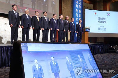 제54회 한일경제인회의(서울=연합뉴스) 김주성 기자 = 30일 오후 서울 중구 롯데호텔에서 열린 제54회 한일경제인회의에서 안덕근 산업부 통상교섭본부장(왼쪽 네번째)과 한국경제협회장인 김윤 삼양홀딩스 회장(왼쪽 다섯번째)을 비롯한 기업인들이 화상으로 연결된 일본 도쿄 호텔오쿠라의 일본측 참석자들과 동시에 기념촬영을 하고 있다. 2022.5.30 utzzza@yna.co.kr