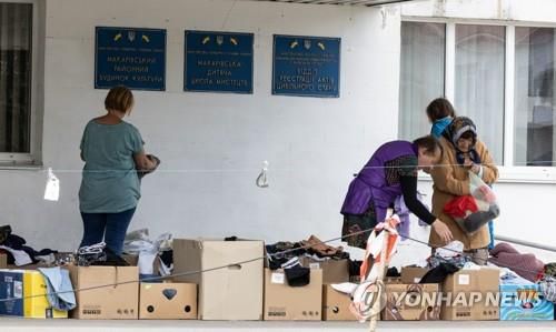 헌 옷 고르는 마카리우 시민들지난 6월 15일(현지시간) 우크라이나 수도 키이우에서 서쪽으로 약 60㎞ 떨어진 마카리우 시내에서 사람들이 구호단체가 지원한 헌 옷이 담긴 상자를 뒤적거리고 있다. [연합뉴스 자료사진]