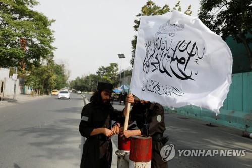 카불에서 탈레반 상징 깃발을 꼽는 탈레반 대원.[로이터 연합뉴스 자료사진. 재판매 및 DB 금지]