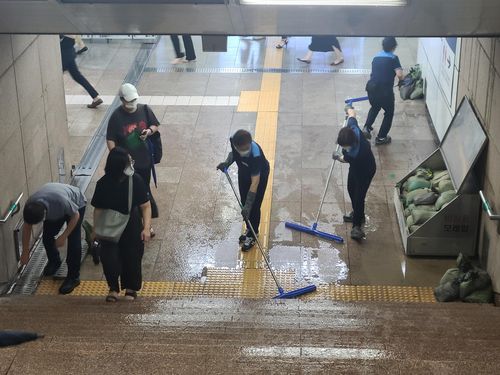 고인 빗물 정리하는 광화문역 관계자들[촬영 박규리]