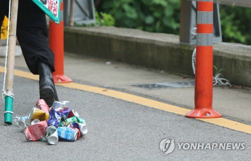 깡통까지소음을 내려고 빈 깡통을 묶어 질질 끌고 다니면서 1인 시위를 하는 A 씨. [연합뉴스 자료사진]