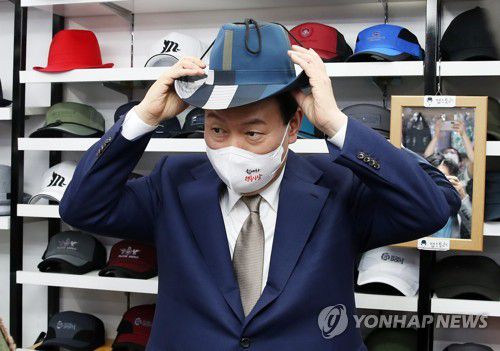 모자 써보는 윤석열 대통령(대구=연합뉴스) 서명곤 기자 = 윤석열 대통령이 26일 오후 대구 중구 서문시장 내 모자 가게를 방문, 모자를 써보며 상인들과 대화하고 있다.  2022.8.26 seephoto@yna.co.kr