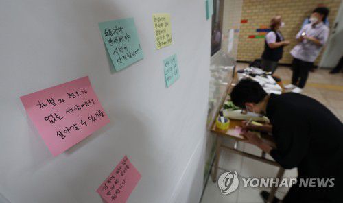 추모 메시지 쓰는 시민들(서울=연합뉴스) 김인철 기자 = 15일 오후 전 서울교통공사 직원 전모씨가 20대 동료 여성 역무원을 뒤쫓아가 살해한 사건이 발생한 서울 지하철 2호선 신당역 여자화장실 입구에 마련된 추모공간에서 시민들이 추모 메시지를 쓰고 있다. 2022.9.15 yatoya@yna.co.kr