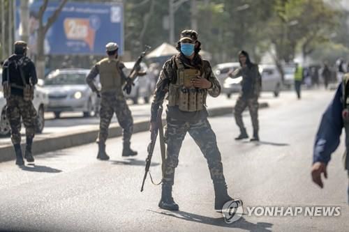 23일 아프간 카불 모스크 인근 폭탄 테러 현장에서 경계 활동 중인 탈레반.[AP 연합뉴스 자료사진. 재판매 및 DB 금지]