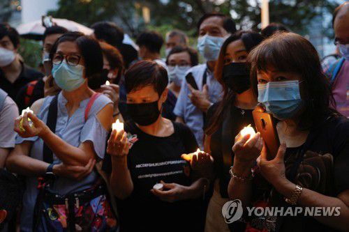 (로이터=연합뉴스) 지난 19일 엘리자베스 2세 영국 여왕의 장례식이 열리던 시각 홍콩 주재 영국 총영사관 앞에서 촛불을 들어 올린 조문객들. 2022.9.24.
