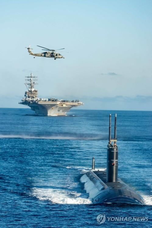 한미일 대잠전 훈련(서울=연합뉴스) 한미일 대잠전 훈련에 참가한 미국 측 전력들이 30일 동해 공해상에서 기동훈련을 하고 있다. 사진은 미국 원자력 추진 잠수함 아나폴리스함(앞쪽부터), 미국 원자력 추진 항공모함 로널드 레이건함, 미국 해상작전 헬기 MH-60 시호크. 2022.9.30 [해군 제공. 재판매 및 DB 금지] photo@yna.co.kr