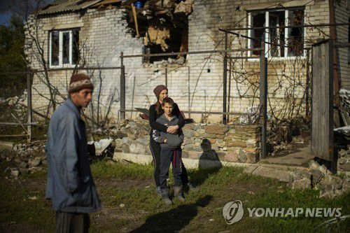 폐허가 된 리만 인근 마을에서 만난 주민들(AP=연합뉴스) 우크라이나군이 수복한 리만 인근 마을에 4일(현지시간) 주민들이 모여 있다. 재판매 및 DB 금지.