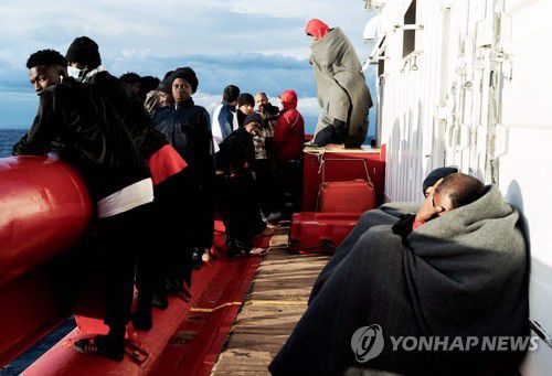 하선 기다리는 이주민들(AFP=연합뉴스) 6일(현지시간) 난민 구조선 '오션 바이킹'호에 탑승한 이주민들이 갑판에서 밖을 바라보며 하선을 기다리고 있다. 2022.11.07 photo@yna.co.kr