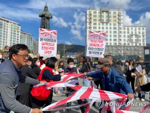 욱일기 찢기(창원=연합뉴스) 지난달 29일 경남 창원시 진해구 북원로터리 이순신 장군 상 앞에서 열린 '친일 국방 규탄' 기자회견에서 참가자들이 욱일기를 찢고 있다.     민주노총 경남본부 등 참석자들은 정부가 '일본 해상자위대 창설 70주년 관함식'에 해군 함정을 보내기로 한 데 대해 "참가를 철회하라"고 밝혔다. 2022.10.29 [민주노총 경남본부 제공. 재판매 및 DB 금지] image@yna.co.kr
