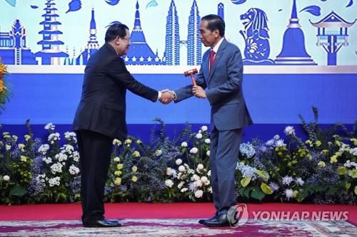 아세안 의장직을 조코 위도도 인니 대통령에게 넘기고 있는 훈센 캄보디아 총리[로이터=연합뉴스. 재판매 및 DB 금지]