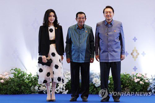 '아세안+3' 갈라만찬 참석하는 윤석열 대통령 내외(프놈펜=연합뉴스) 서명곤 기자 = 윤석열 대통령과 김건희 여사가 12일 오후(현지시간)  캄보디아 프놈펜 쯔노이짱바 국제 컨벤션센터에서  '아세안+3' 의장국인 캄보디아 정상이 주최하는 갈라 만찬에 참석, 훈센 총리와 기념촬영을 하고 있다. 2022.11.13 seephoto@yna.co.kr