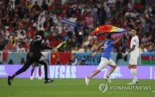 그라운드로 들어온 관중(루사일=연합뉴스) 임헌정 기자 = 28일 오후(현지시간) 카타르 루사일 스타디움에서 열린 2022 카타르 월드컵 조별리그 H조 2차전 포르투갈 대 우루과이 경기.      경기 도중 이란 여성의 자유를 호소하는 티셔츠를 입은 남성이 무지개 깃발을 들고 그라운드를 내달리고 있다. 2022.11.29 kane@yna.co.kr