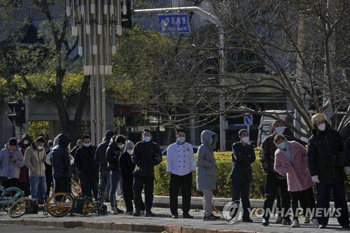 (AP=연합뉴스) 지난달 30일 추위가 몰아닥친 중국 베이징에서 주민들이 코로나19 검사를 받기 위해 길게 줄을 선 모습.