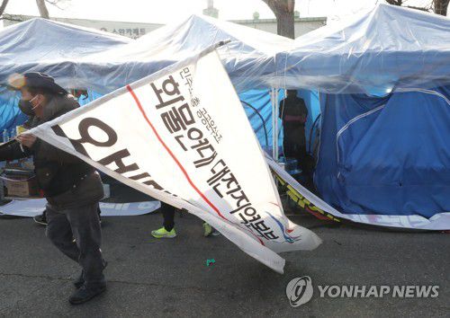 화물연대 조합원들 천막 철거(대전=연합뉴스) 이주형 기자 = 민주노총 화물연대 대전본부 조합원들이 9일 오후 대전 대덕우체국 앞 화물연대 거점 시위 현장에서 철수하고 있다.  화물연대는 총파업 16일째를 맞은 이날 조합원 투표를 거쳐 파업을 종료하고 업무 복귀하기로 했다. 2022.12.9 coolee@yna.co.kr