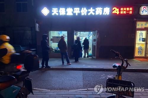 약 구매 위해 약국 앞에 줄 선 中 베이징 시민들  (베이징 AFP=연합뉴스) 코로나19 팬데믹이 지속되는 가운데 12일(현지시간) 중국 베이징의 한 약국 앞에서 약을 사려는 시민들이 줄을 서 있다. 현지 매체들은 베이징의 발열환자 수가 일주일 새 16배 급증했다고 13일 보도했다. 2022.12.13     ddy04002@yna.co.kr
