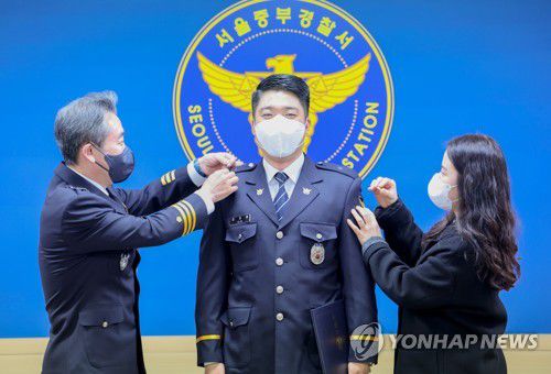 검거 유공자 특진 계급장 달아주는 윤희근 경찰청장(서울=연합뉴스) 류영석 기자 = 윤희근 경찰청장이 16일 오전 서울중부경찰서에서 열린 김지훈 경위 특별승진 임용식에 참석해 김 경위에게 계급장을 달아주고 있다.     김 경위는 건설현장 내 건설사를 상대로 공동공갈 불법행위를 한 노조원들을 검거했다. 2022.12.16 ondol@yna.co.kr