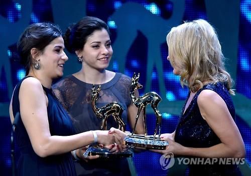 2016년 독일 언론사 후베르트 부르다가 수여하는 '숨은 영웅' 상을 받은 사라 마르디니(왼쪽)와 유스라 마르디니(가운데) 자매. [EPA 연합뉴스 자료사진. 재판매 및 DB 금지]
