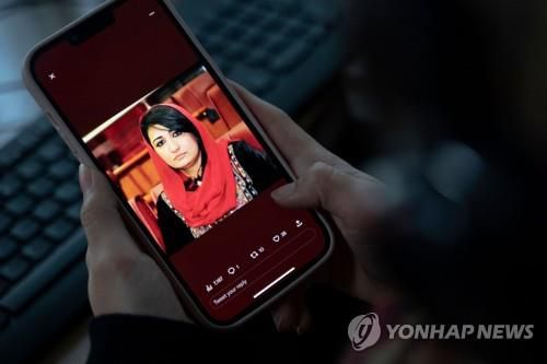 무르살 나비자다 전 아프간 의원의 사진을 살펴보는 현지 주민. [AFP 연합뉴스 자료사진. 재판매 및 DB 금지]