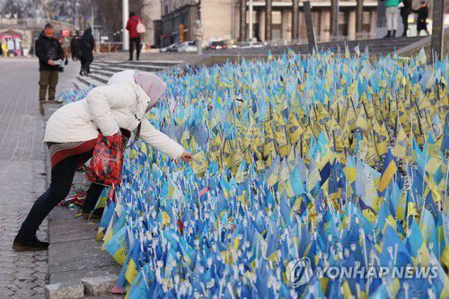 키이우 광장 전쟁 희생자 추모 깃발(키이우[우크라이나]=연합뉴스) 류영석 기자 = 7일(현지시간) 정교회 성탄절을 맞은 우크라이나 수도 키이우 독립 광장에서 한 시민이 러시아 침공 희생자 추모 공간을 살피고 있다. 2023.1.8 ondol@yna.co.kr
