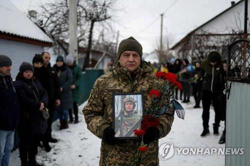 안드로슈크의 장례식(레티치우 로이터=연합뉴스) 러시아와 전투 중에 세상을 떠난 우크라이나 육상 10종 경기 선수 볼로디미르 안드로슈크의 장례식이 1일(현지시간) 우크라이나 서부 레티치우에서 거행되고 있다. 안드로슈크의 형이 영정을 들고 있는 모습.