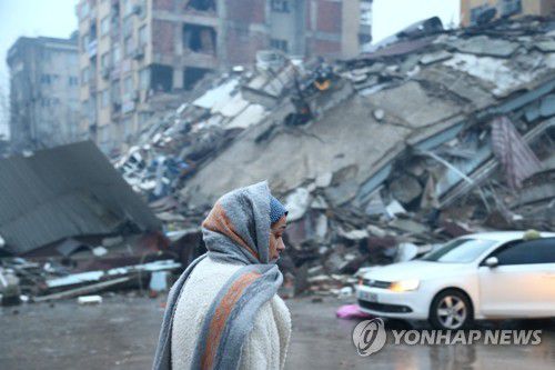 튀르키예 카흐라만마라슈에서 무너진 건물 앞의 여성[로이터 연합뉴스 자료사진. 재판매 및 DB 금지]