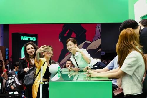 팬들과 사진을 찍는 야옹이 작가[연합뉴스 자료사진. 네이버웹툰 제공]