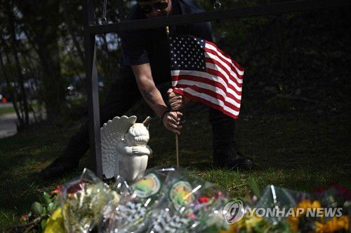 美 테네시주 초교 총기난사 희생자 추모하는 시민(내슈빌 AFP=연합뉴스) 28일(현지시간) 미국 테네시주 내슈빌의 사립 초등학교 커버넌트스쿨 건물에 마련된 임시 추모소에서 한 시민이 총기난사 희생자들을 기리며 천사상과 깃발을 놓고 있다. 전날 오전 이 학교 출신의 성전환자 여성 오드리 헤일(28)이 모교에서 총을 마구 쏴 학생 3명을 포함해 6명을 숨지게 했다. 헤일은 이후 경찰 총에 맞아 사망했다. 2023.03.29 ddy04002@yna.co.kr