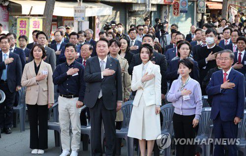 대구 서문시장 100주년 기념식 참석한 윤석열 대통령 내외(대구=연합뉴스) 안정원 기자 = 윤석열 대통령과 김건희 여사가 1일 대구 서문시장 인근에서 열린 '서문시장 100주년 기념식'에서 국기에 경례하고 있다. 2023.4.1 jeong@yna.co.kr