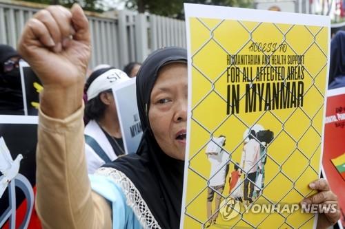 '난민의 날' 맞아 인도네시아서 미얀마 난민 지원 촉구하는 운동가(자카르타 EPA=연합뉴스) 인도네시아 운동가가 20일(현지시간) 자카르타의 아세안(ASEAN·동남아시아국가연합) 본부 앞에서 미얀마 난민들에 대한 지원을 촉구하는 포스터를 들고 있다. '세계 난민의 날'은 전 세계 난민들을 기리는 날로 매년 6월 20일이다. 2023.06.20 danh2023@yna.co.kr