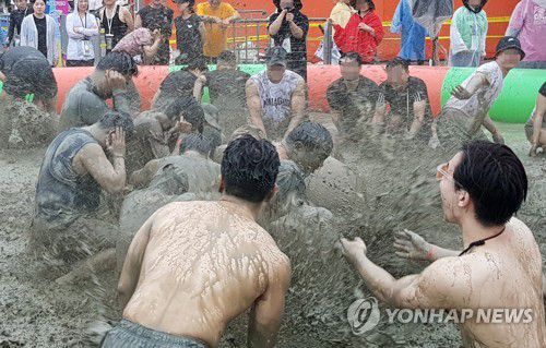 빗속에도 신나는 머드 체험(보령=연합뉴스) 제26회 보령머드축제가 개막한 첫 주말인 지난 22일 충남 보령 대천해수욕장 일대에서 외국인 관광객을 포함한 시민들이 축제를 즐기고 있다. 보령머드축제는 다음 달 6일까지 계속된다. [연합뉴스 자료사진]