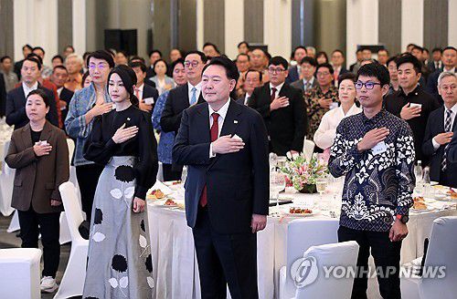 윤 대통령 내외, 인도네시아 동포 초청 만찬 간담회 참석(자카르타=연합뉴스) 임헌정 기자 = 동아시아국가연합(아세안·ASEAN) 정상회의 참석차 인도네시아를 방문 중인 윤석열 대통령과 김건희 여사가 5일(현지시간) 자카르타 시내 한 호텔에서 열린 인도네시아 동포 초청 만찬 간담회에서 국기에 경례하고 있다. 2023.9.5 kane@yna.co.kr