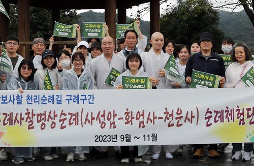 명상순례길 체험단과 기념사진 찍는 꽃스님(구례=연합뉴스) 이세원 기자 = 21일 전남 구례군 섬진강 인근 도로에서 '구례사찰명상길' 순례체험단과 이 행사에 명사로 초청된 '꽃스님' 범정스님(오른쪽 첫번째 승려)이 기념 사진 촬영에 응하고 있다.