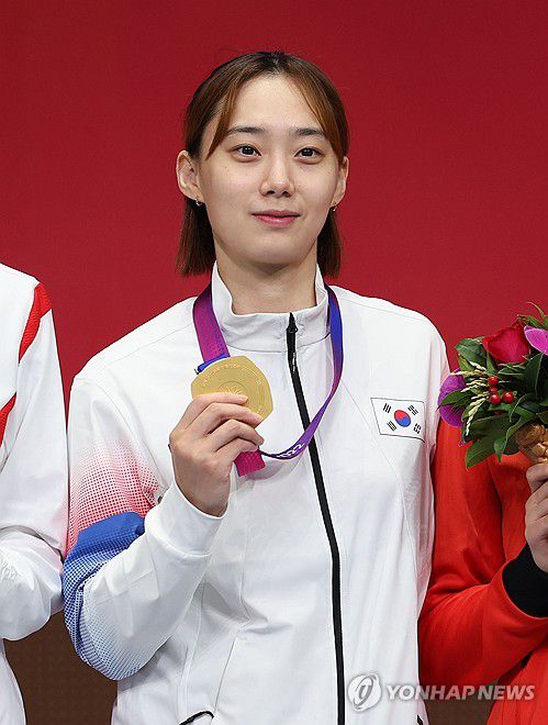 윤지수, 오늘의 '1등 검객'(항저우=연합뉴스) 김인철 기자 = 26일 중국 항저우 전자대학 체육관에서 열린 19회 항저우 아시안게임 펜싱 여자 사브르 개인 결승전에서 금메달을 획득한 윤지수가 시상대에 올라 메달을 목에 걸고 있다. 2023.9.26 yatoya@yna.co.kr