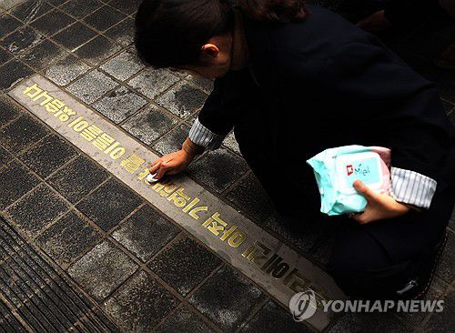바닥 문구 닦는 관계자(서울=연합뉴스) 최재구 기자 = 26일 서울 이태원 참사 현장에서 참사 1주기를 맞아 '10.29 기억과 안전의 길'이 이태원 참사 유가족협의회와 이태원 참사 시민대책회의에 의해 공개되었다. 한 관계자가 바닥에 있는 '우리에겐 아직 기억해야 할 이름들이 있습니다'라는 문구가 담긴 명판을 닦고 있다. 2023.10.26 jjaeck9@yna.co.kr