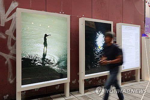 사고현장에 설치된 빌보드(서울=연합뉴스) 최재구 기자 = 26일 서울 이태원 참사 현장에서 참사 1주기를 맞아 '10.29 기억과 안전의 길'이 이태원 참사 유가족협의회와 이태원 참사 시민대책회의에 의해 공개되었다. 한 시민이 골목에 설치된 빌보드 앞을 지나고 있다. 2023.10.26 jjaeck9@yna.co.kr