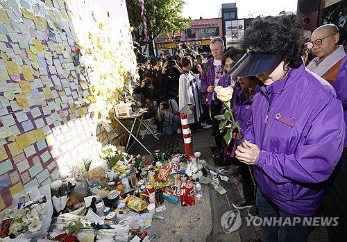 헌화하는 이태원 참사 유가족(서울=연합뉴스) 임화영 기자 = 10·29 이태원 참사 1주기를 맞은 29일 오후 서울 용산구 이태원 참사 현장에 마련된 '10·29 기억과 안전의 길'의 추모 공간'에서 유가족이 헌화하고 있다. 2023.10.29 [공동취재] hwayoung7@yna.co.kr