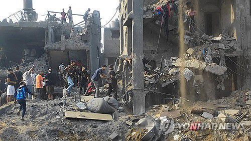 31일(현지시간) 팔레스타인 가자지구 북부 자발리아 난민촌의 건물 잔해에서 주민들이 구조 작업 중이다.[로이터=연합뉴스]