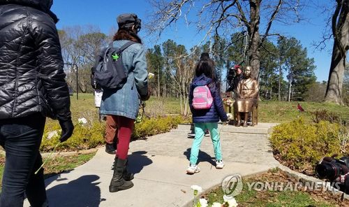 미국 브룩헤이븐시에 설치된 평화의 소녀상(애틀랜타=연합뉴스) 이종원 통신원 = 2022년 3월 12일(현지시간) 미국 조지아주 브룩헤이븐 시에서 열린 애틀랜타 총격 1주년 추모 집회에서 현지 주민들이 평화의 소녀상에 헌화하고 있다. [연합뉴스 자료사진. 재판매 및 DB금지]