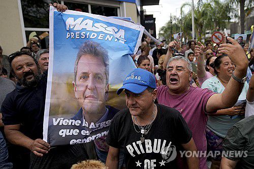 승리 다짐하는 마사 후보 지지자(에세이사[아르헨티나] AP=연합뉴스) 15일(현지시간) 아르헨티나 에세이사에서 세르히오 마사 후보 지지자가 '마사 대통령'이라고 인쇄된 포스터를 들어 보이고 있다. 2023.11.17