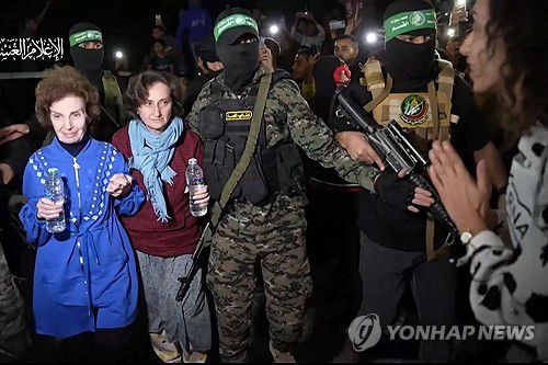 29일(현지시간) 하마스 대원들에 이끌려 석방되고 있는 인질들[AFP=연합뉴스]