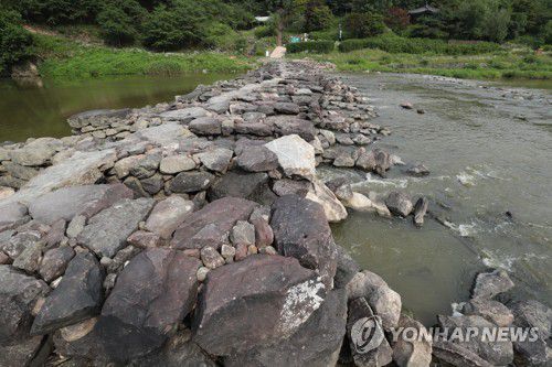 진천 농다리(진천=연합뉴스) 조보희 기자 = 농다리는 충북 진천군 문백면 구곡리의 굴티마을 앞에 있다. 멀리서 보면 다리가 아니라 마치 돌무더기처럼 보인다. 교각을 세우고 반듯하게 돌을 깎아 만든 다리가 아니라 돌을 원래의 모양 그대로 쌓아 투박하기 때문이다. 겉모습은 듬성듬성 구멍도 뚫리고 발로 밟으면 삐걱거리며 움직인다. 큰 돌을 쌓고 그 사이엔 작은 돌을 끼워 넣었다. 하지만 놀랍게도 천년 세월을 이겨낸 다리다.  2019.7.4