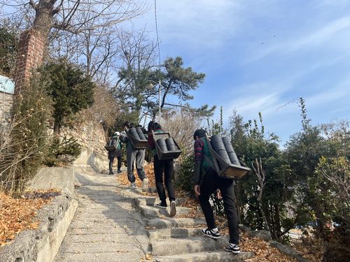 연탄 나르는 자원봉사자들(서울=연합뉴스) 김정진 기자 = 5일 오전 서울 노원구 상계동 마을에 서울연탄은행 자원봉사자들이 연탄을 배달하고 있다. 2023.12.5 stopn@yna.co.kr