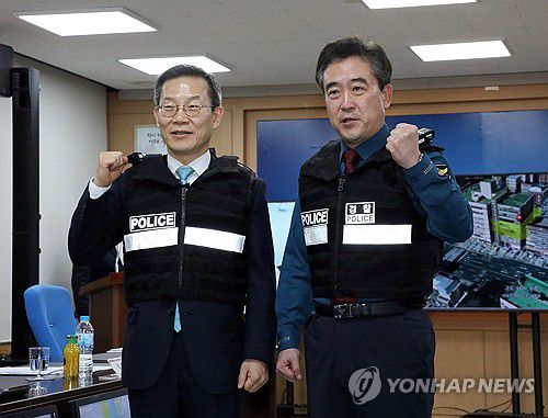 디지털 범죄 안전 관계기관 협력 강화 회의(서울=연합뉴스) 배재만 기자 = 윤희근 경찰청장과 이종호 과학기술정보통신부 장관이 6일 오후 서울 도봉경찰서에서 열린 디지털 기술 기반 범죄예방 기술 시연 및 MOU에서 차세대 외근 조끼를 입고 파이팅을 외치고 있다. 2023.12.6 scoop@yna.co.kr