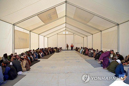 아프간 도착 직후 등록센터서 점심식사를 하는 파키스탄 내 불법체류 아프간인들[AFP 연합뉴스 자료사진. 재판매 및 DB 금지]