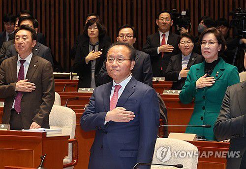 국민의힘 의원총회(서울=연합뉴스) 이정훈 기자 = 국민의힘 윤재옥 원내대표와 의원들이 8일 국회에서 열린 의원총회에서 국기에 경례하고 있다. 2023.12.8 uwg806@yna.co.kr