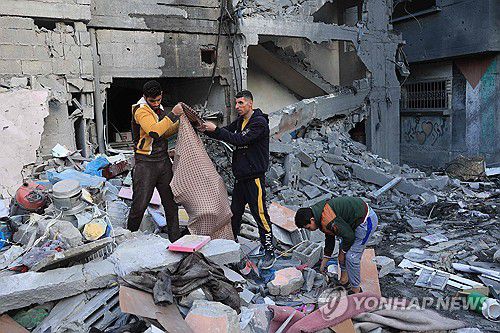 공습으로 무너진 건물 잔해 뒤지는 팔레스타인 주민들(AFP=연합뉴스) 9일(현지시간) 가자지구 남부 라파에서 주민들이 쓸만한 물건을 건지기 위해 이스라엘 공습으로 부서진 건물 잔해를 뒤지는 모습. 2023. 12.9