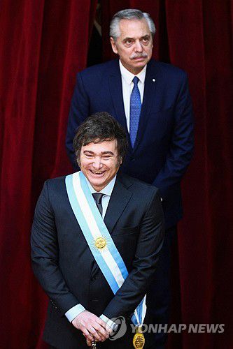 아르헨티나 정권 교체(부에노스아이레스 로이터=연합뉴스) 하비에르 밀레이(앞) 아르헨티나 대통령이 10일(현지시간) 부에노스아이레스 연방 의회에서 환하게 웃고 있다. 뒤쪽은 퇴임한 알베르토 페르난데스 전 대통령. 2023.12.11